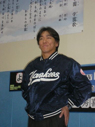 学園歌が貼られた壁の前で