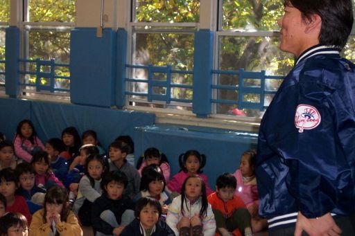 床に座って松井選手を見上げる子どもたち