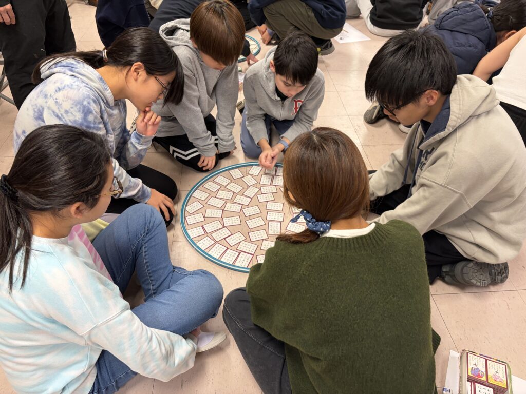 真剣に百人一首の札を探す中学生