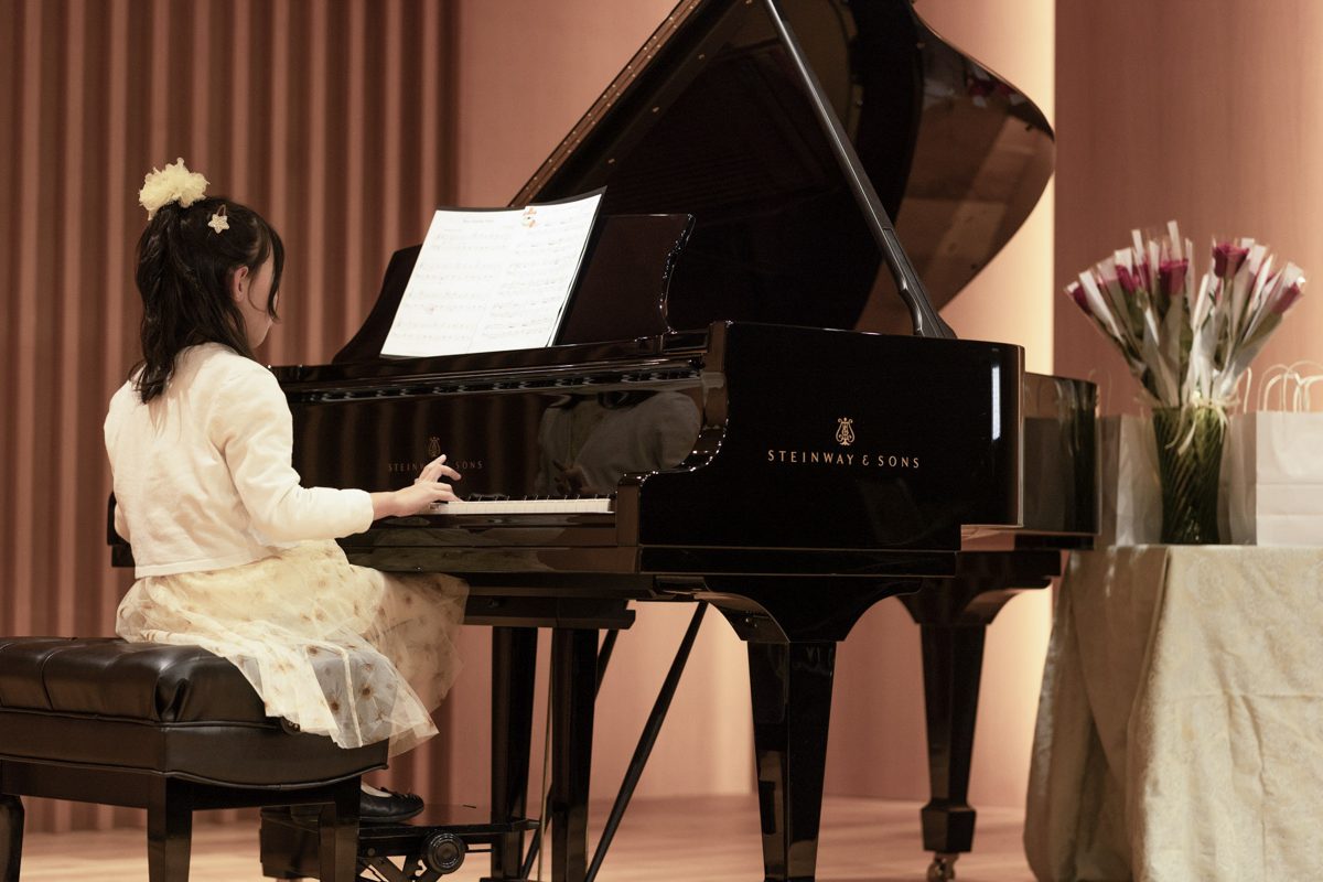 A child performing on the concert hall grand piano