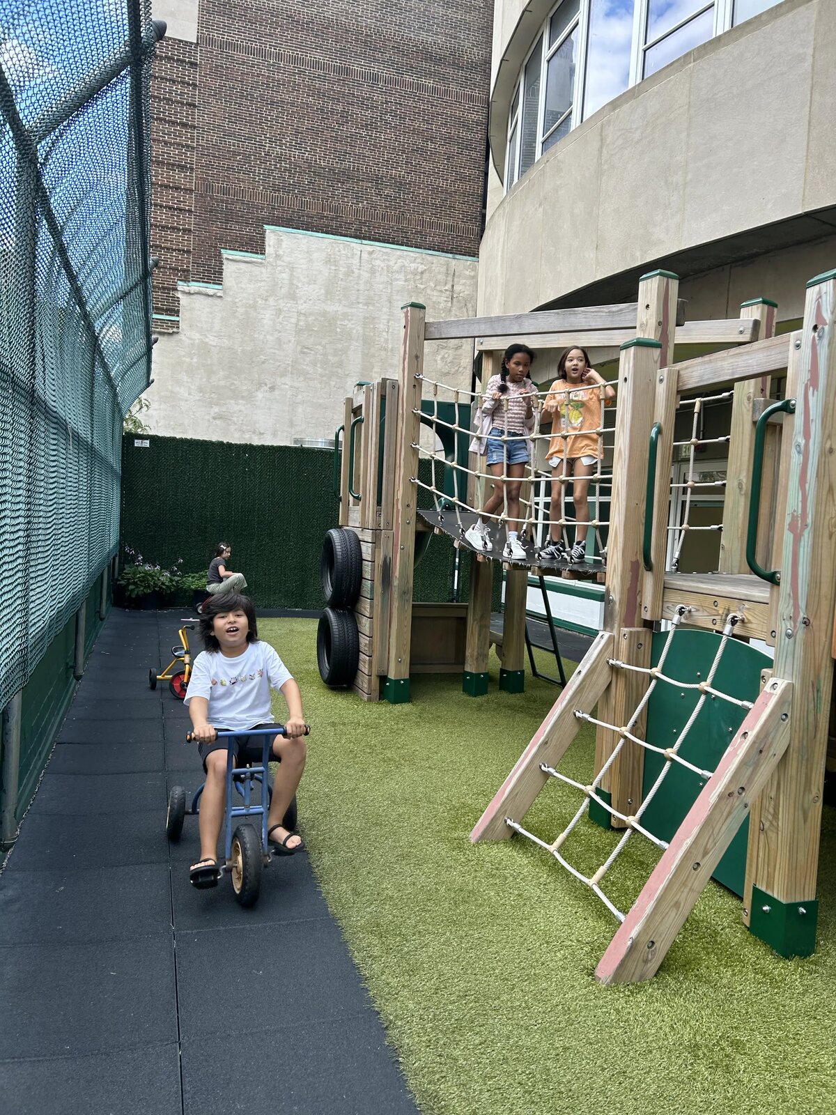 屋外プレイエリアのクライミング遊具で遊ぶ子どもたち