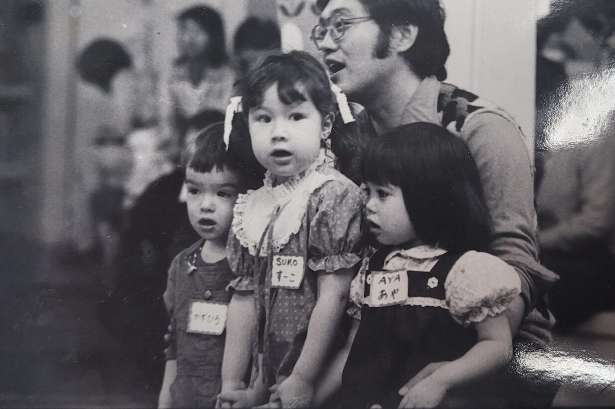 1981年ごろ、よい子の学園で子どもたちとあいさつの歌を歌う岡本前学園長