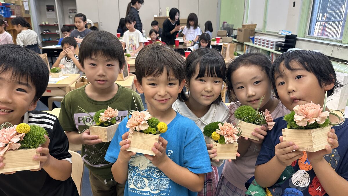 升花の作品を持って笑顔の子どもたち