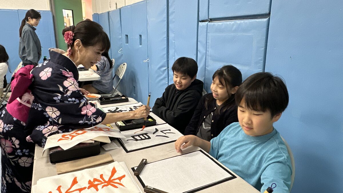 理白先生から書道の指導を受ける子どもたち