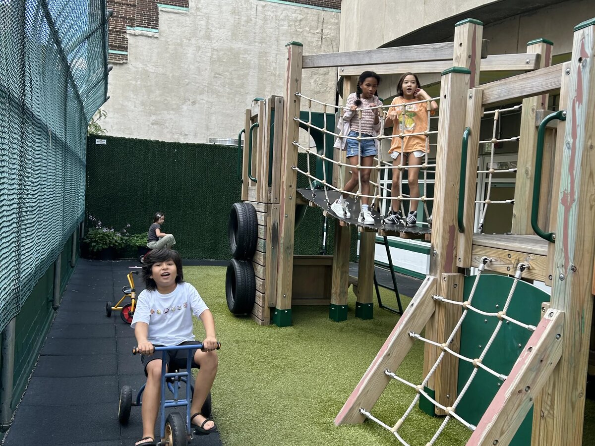 屋外プレイエリアの遊具で遊ぶ子どもたち