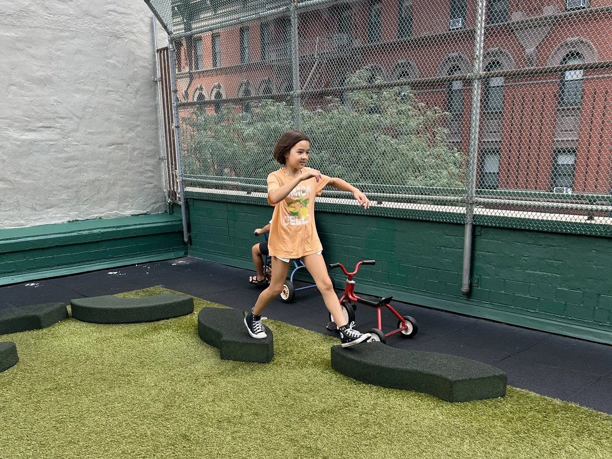屋外プレイエリアの飛び石で遊ぶ子ども