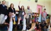 手を挙げる子どもたちの前に立つ外交官研修生たち