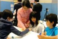 グループで話し合う子どもたちと大学生
