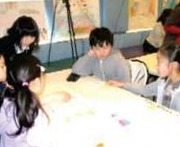 大きな紙を囲んで話し合う子どもたち