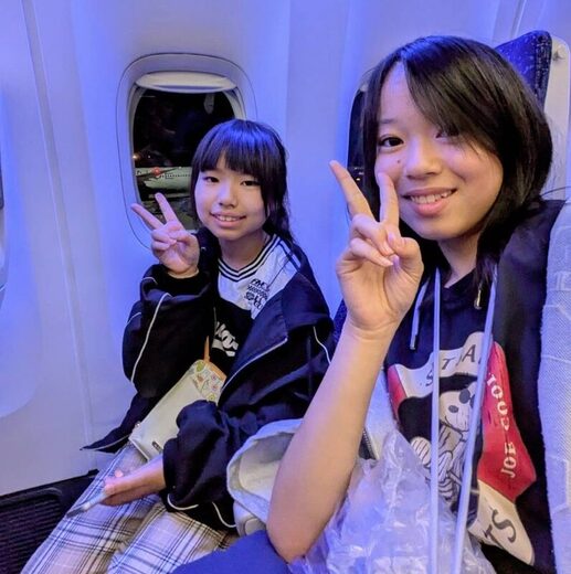 機内でピースサインをする植杉さんと橋本さん